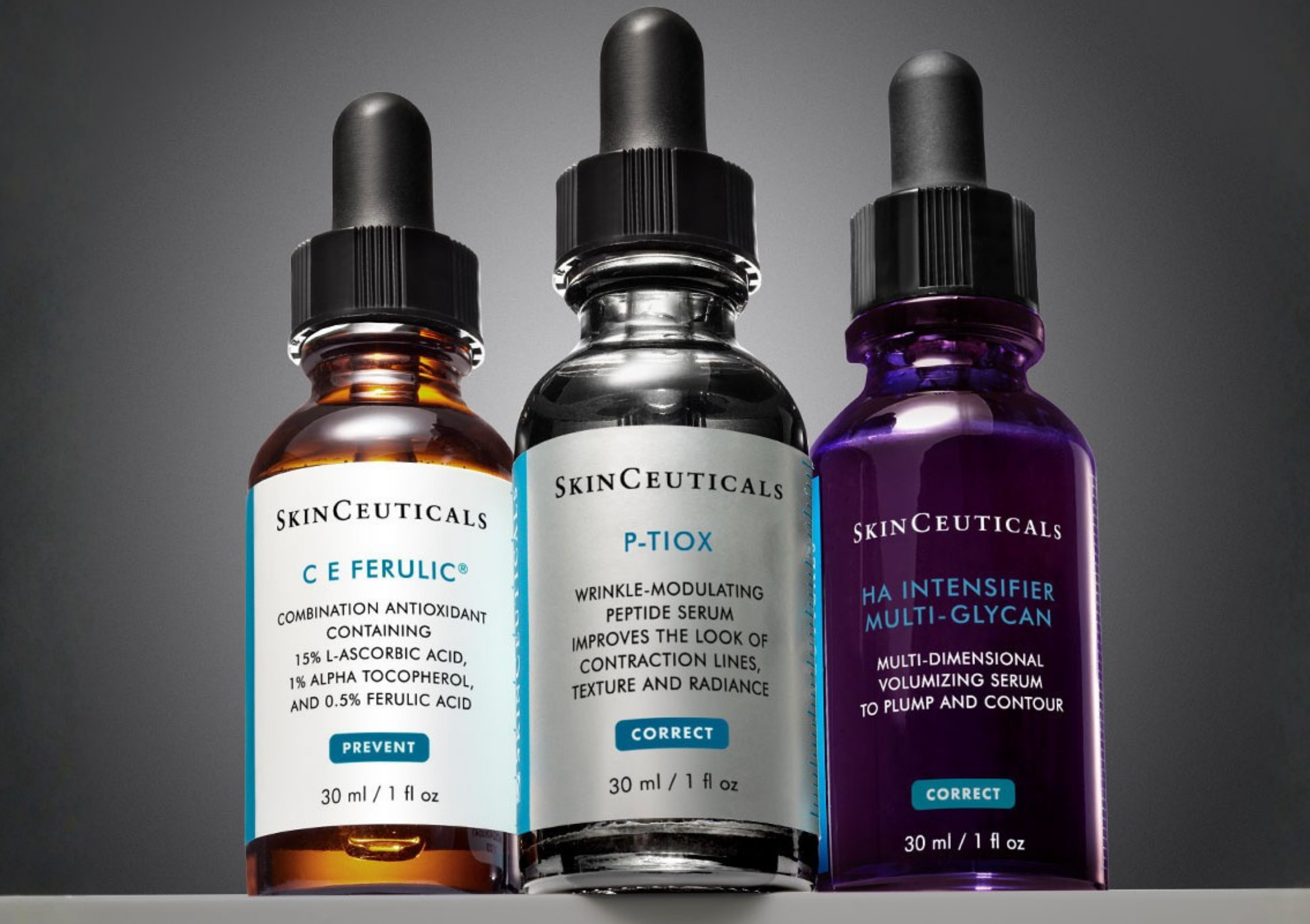 Three SkinCeuticals serum bottles with dropper tops in orange, clear, and purple liquids, displayed against a gray gradient background.